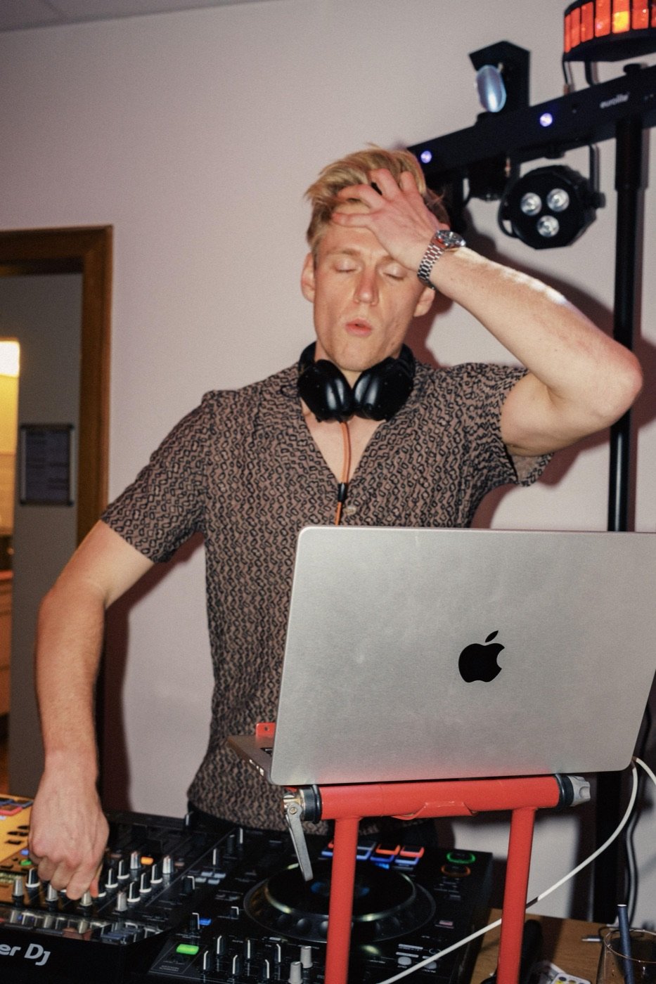 DJ Tim Matthiä bei einer Sommerparty unter bunten Wimpeln