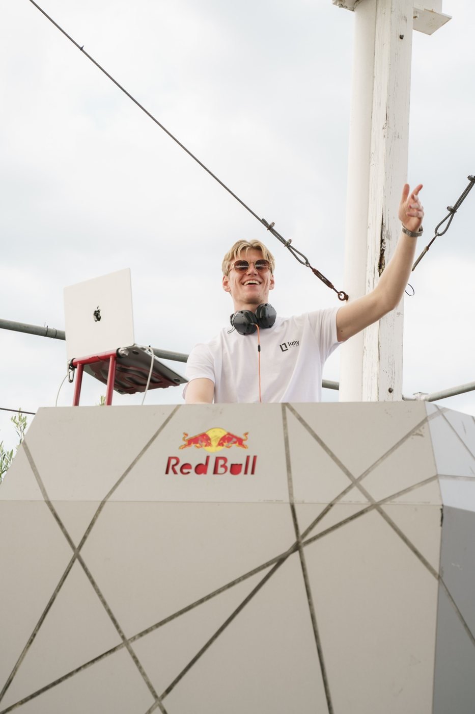 DJ Tim Matthiä lachend mit Sonnenbrille am DJ-Pult unter freiem Himmel