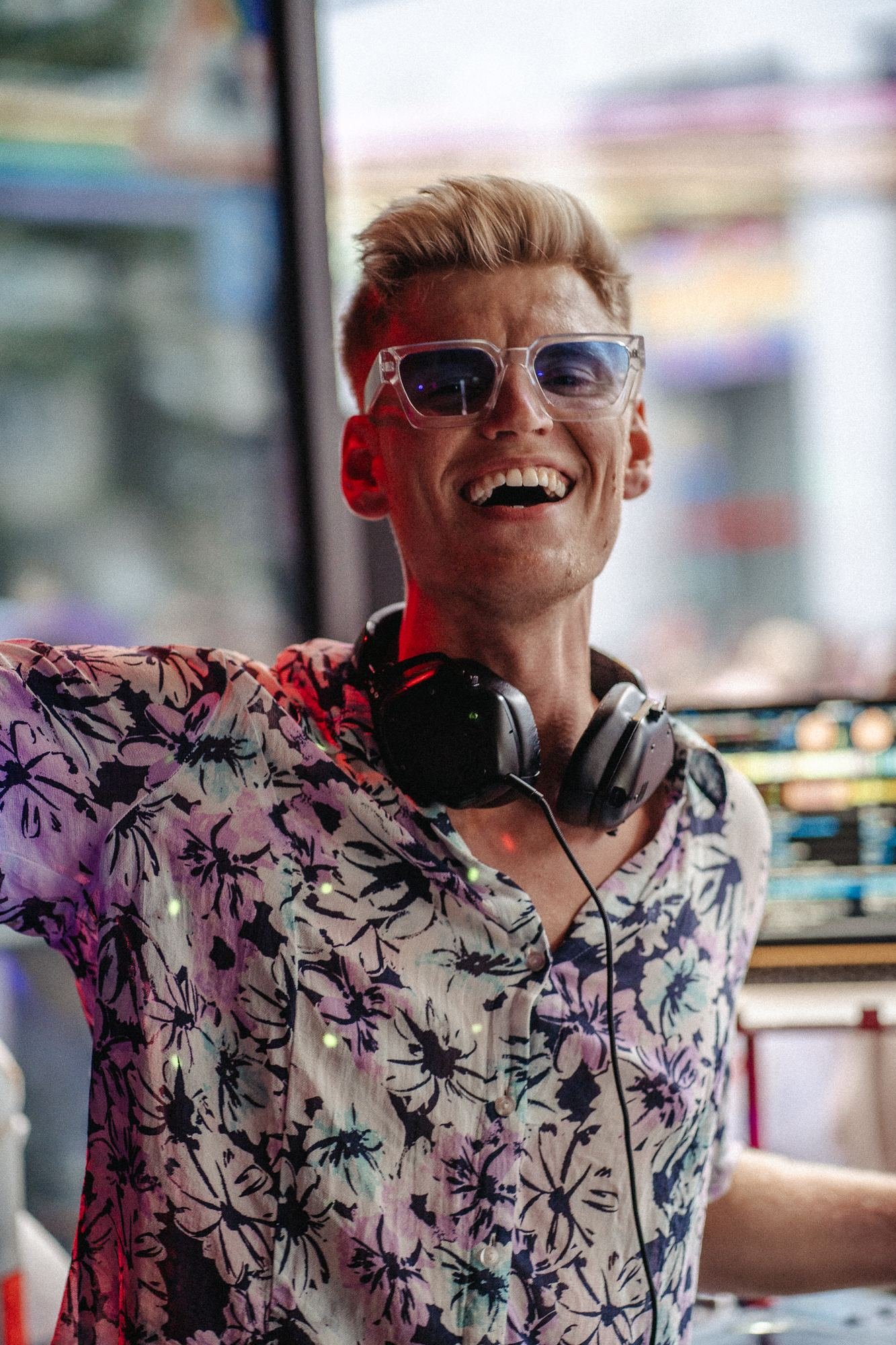 DJ Tim Matthiä lächelnd im Blumenhemd bei einem Auftritt in der Iron Bar