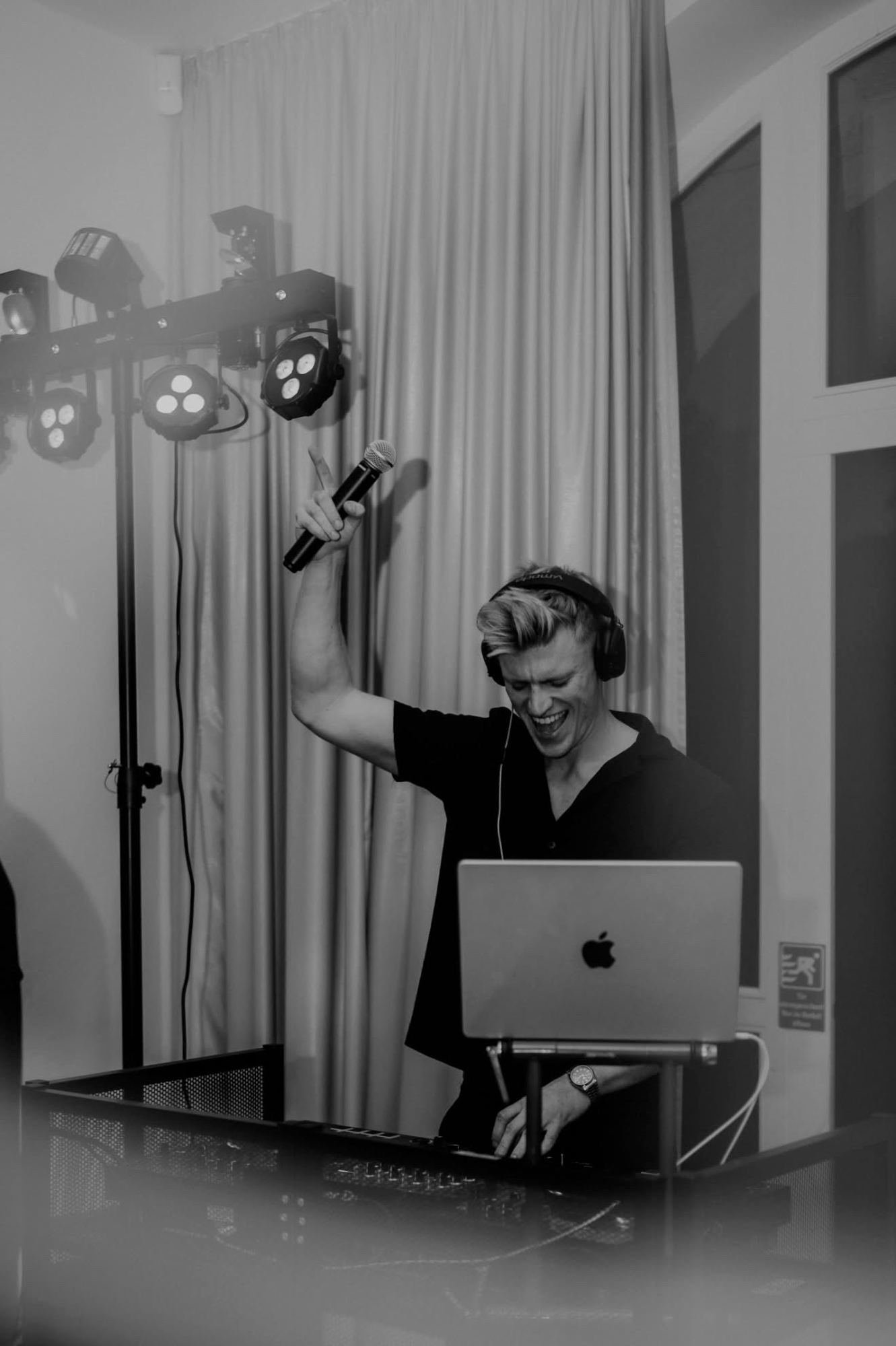 DJ Tim Matthiä mit Mikrofon in der Hand als Hochzeits-DJ, Schwarz-Weiß-Aufnahme